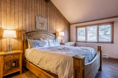 a bedroom with a large bed with a wooden wall at Mountainback 80 in Mammoth Lakes