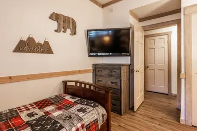 a bedroom with a bed and a flat screen tv at Mountainback 80 in Mammoth Lakes