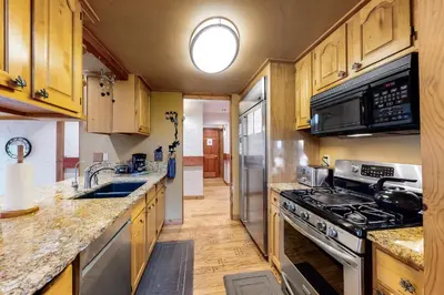 a kitchen with wooden cabinets and stainless steel appliances at The Acorn House in Truckee