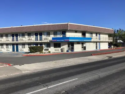 a white building with a red roof and a street at Motel 6-Reno, NV - Livestock Events Center in Reno