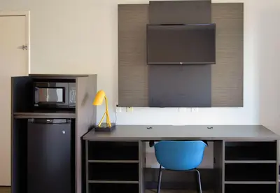 a kitchen with a desk with a microwave and a blue chair at Motel 6-Reno, NV - Livestock Events Center in Reno