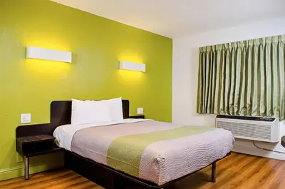 a bedroom with a bed with green walls and a window at Motel 6-Modesto, CA - Downtown in Modesto