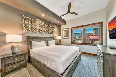 a bedroom with a bed and a desk and a window at Luxury 2Br Residence Steps From Heavenly Village & Gondola Condo in South Lake Tahoe