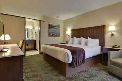 a hotel room with a large bed and a couch at Vagabond Inn Bishop in Bishop