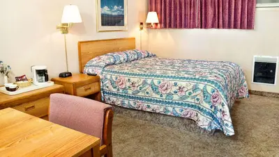 a hotel room with a bed and a table at Ruby Inn Bridgeport in Bridgeport