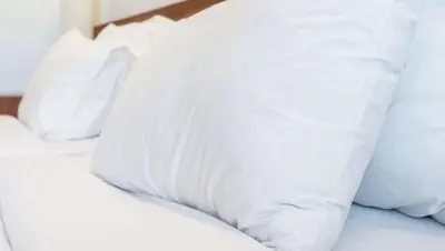 a white bed with white pillows on it at Ruby Inn Bridgeport in Bridgeport