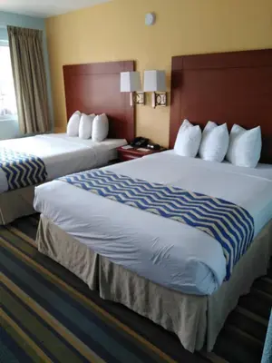 two beds in a hotel room with two bedsskirtspectspectspects at Travelodge by Wyndham Bishop in Bishop
