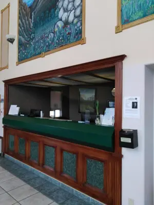a cashier counter at a restaurant with a painting on the wall at Travelodge by Wyndham Bishop in Bishop