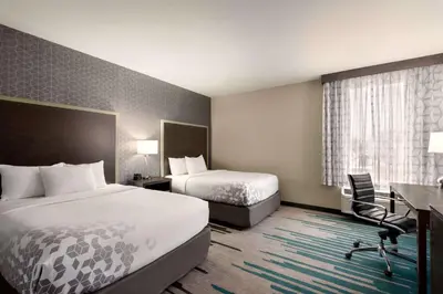 a hotel room with two beds and a desk at La Quinta by Wyndham Clovis CA in Clovis