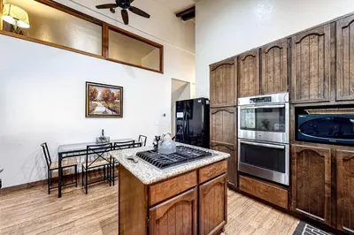 a kitchen with wooden cabinets and a table with a stove at Cherry Retreat in South Lake Tahoe