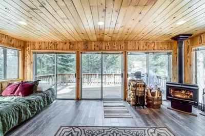 a living room with a bed and a fireplace at Tamarack Dream in Lakeshore