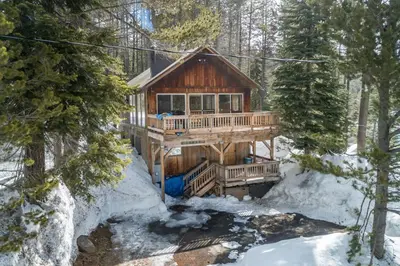 a log cabin in the woods in the snow at Tamarack Dream in Lakeshore