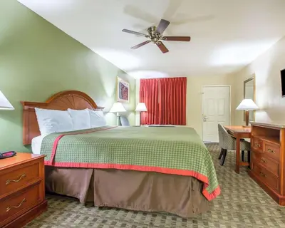 a hotel room with a bed and a ceiling fan at Rodeway Inn Delano in Delano