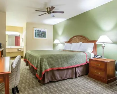 a hotel room with a bed and a ceiling fan at Rodeway Inn Delano in Delano