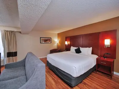 a hotel room with a bed and a chair at Red Lion Inn & Suites Auburn in Auburn