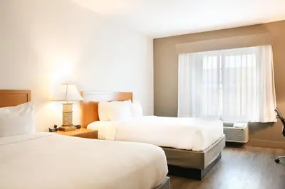 a hotel room with two beds and a window at The Hanford Hotel, an Ascend Collection Hotel in Hanford