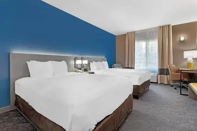 a hotel room with two beds and a desk at Comfort Inn & Suites Sacramento - University Area in Sacramento