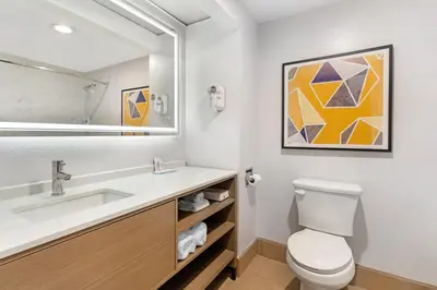 a bathroom with a sink and a toilet and a mirror at Comfort Inn & Suites Sacramento - University Area in Sacramento