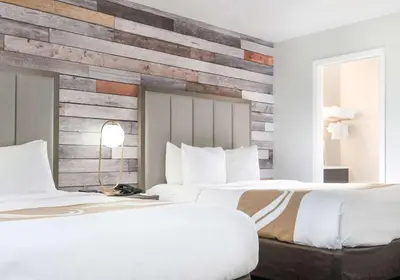 two beds in a hotel room with a reclaimed wood wall at Quality Inn South Lake Tahoe in South Lake Tahoe