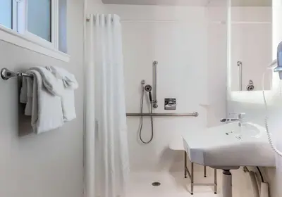 a white bathroom with a shower and a sink at Quality Inn South Lake Tahoe in South Lake Tahoe