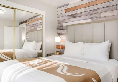 a hotel room with two beds and a mirror at Quality Inn South Lake Tahoe in South Lake Tahoe