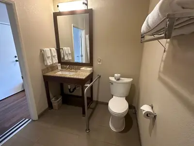 a bathroom with a toilet and a sink and a mirror at Comfort Inn Bishop in Bishop