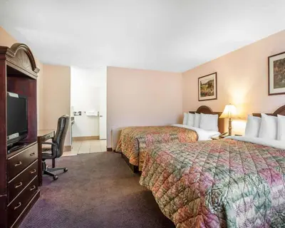 a hotel room with two beds and a flat screen tv at Quality Inn & Suites Cameron Park Shingle Springs in Cameron Park