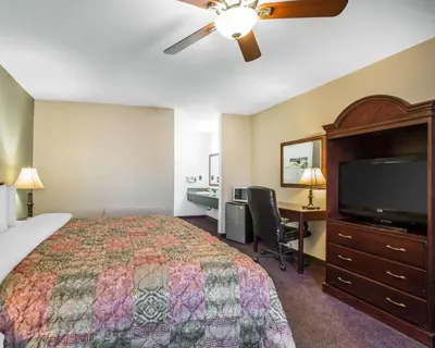 a hotel room with a bed and a flat screen tv at Quality Inn & Suites Cameron Park Shingle Springs in Cameron Park