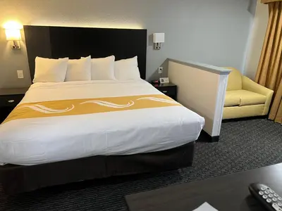 a hotel room with a large bed and a couch at Quality Inn & Suites South San Jose - Morgan Hill in Morgan Hill