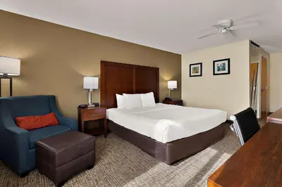 a bedroom with a large bed and a blue chair at Comfort Inn & Suites Sequoia Kings Canyon in Three Rivers