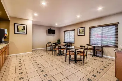 a restaurant with tables and chairs in a room at Quality Inn Fresno Near University in Fresno