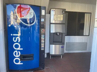 a drink vending machine next to a water dispenser at Hotel Lumberjack - Sonora in Sonora