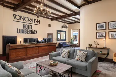 a living room with couches and a tv at Hotel Lumberjack - Sonora in Sonora