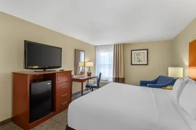 a hotel room with a bed and a flat screen tv at Comfort Inn & Suites Near Fallon Naval Air Station in Fallon
