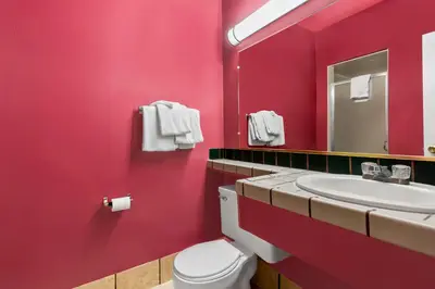 a red bathroom with a toilet and a sink at Econo Lodge Fallon Naval Air Station Area in Fallon