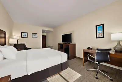 a hotel room with a bed and a desk with a computer at Comfort Inn & Suites Airport Convention Center in Reno
