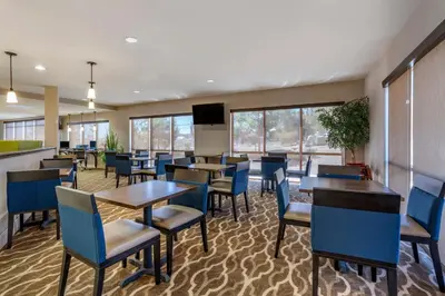 a dining room with tables and chairs and a flat screen tv at Comfort Suites Fernley in Fernley