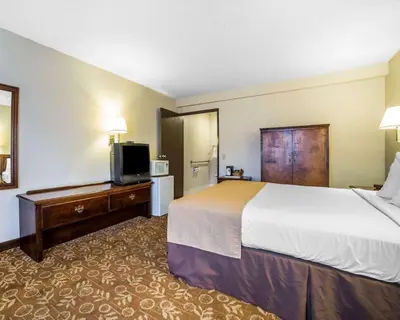 a hotel room with a bed and a flat screen tv at Quality Inn & Suites Minden in Minden