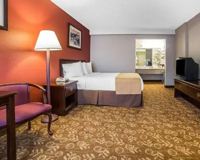 a hotel room with a bed and a chair at Quality Inn & Suites Minden in Minden