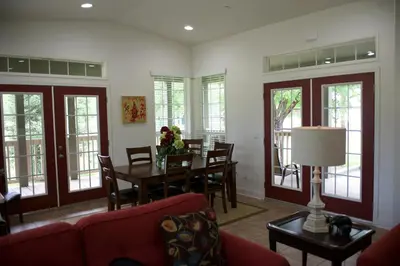 a living room with a table and chairs and windows at Wonder Valley Ranch Resort in Pine Flat Lake