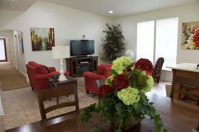 a living room with red chairs and a tv at Wonder Valley Ranch Resort in Pine Flat Lake