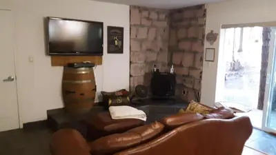 a living room with a couch and a flat screen tv at Winterfell Inn - No Xtra Fees, Dogs OK, King & Queen Suites in Arnold