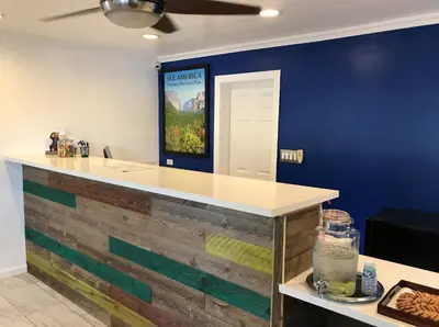 a kitchen with a counter with a blue wall at Signature Inn Merced Yosemite Parkway in Merced