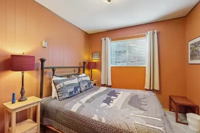 a bedroom with orange walls and a bed and a window at Take me back to Talbot in South Lake Tahoe