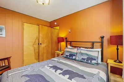 a bedroom with a bed and orange walls at Take me back to Talbot in South Lake Tahoe