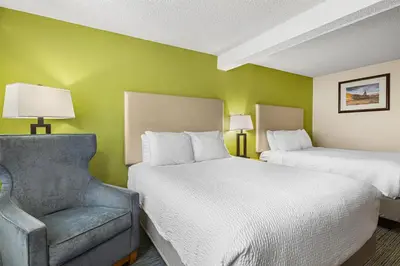 a hotel room with two beds and a chair at Best Western Hi-Desert Inn in Tonopah
