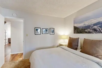 a white bedroom with a bed and mountains at 2 Bed 2 Bath Apartment in Carnelian Bay in Carnelian Bay