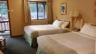 a hotel room with two beds and a window at Wildwood Inn in Twain Harte