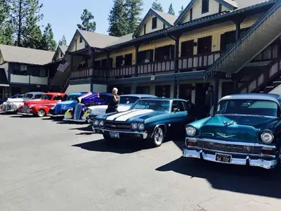 a row of old cars parked in front of a building at Wildwood Inn in Twain Harte