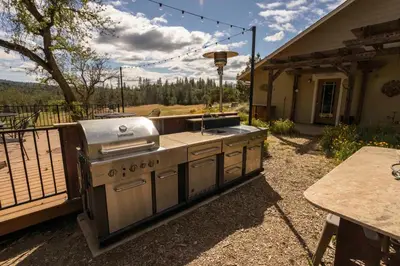 an outdoor kitchen with a grill on a patio at Red Tail Ranch in Groveland